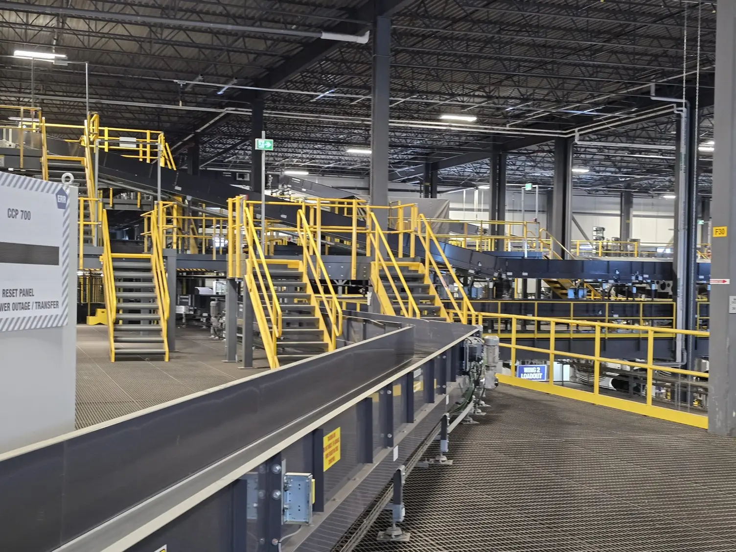 Steel access stairs and platform beside a parcel conveyor