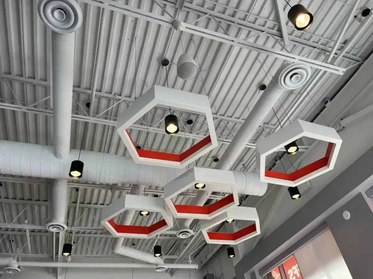 Exposed HVAC ductwork, air diffusers, and pendant lighting on an open ceiling at Mr. Puffs Café in Vaughan.