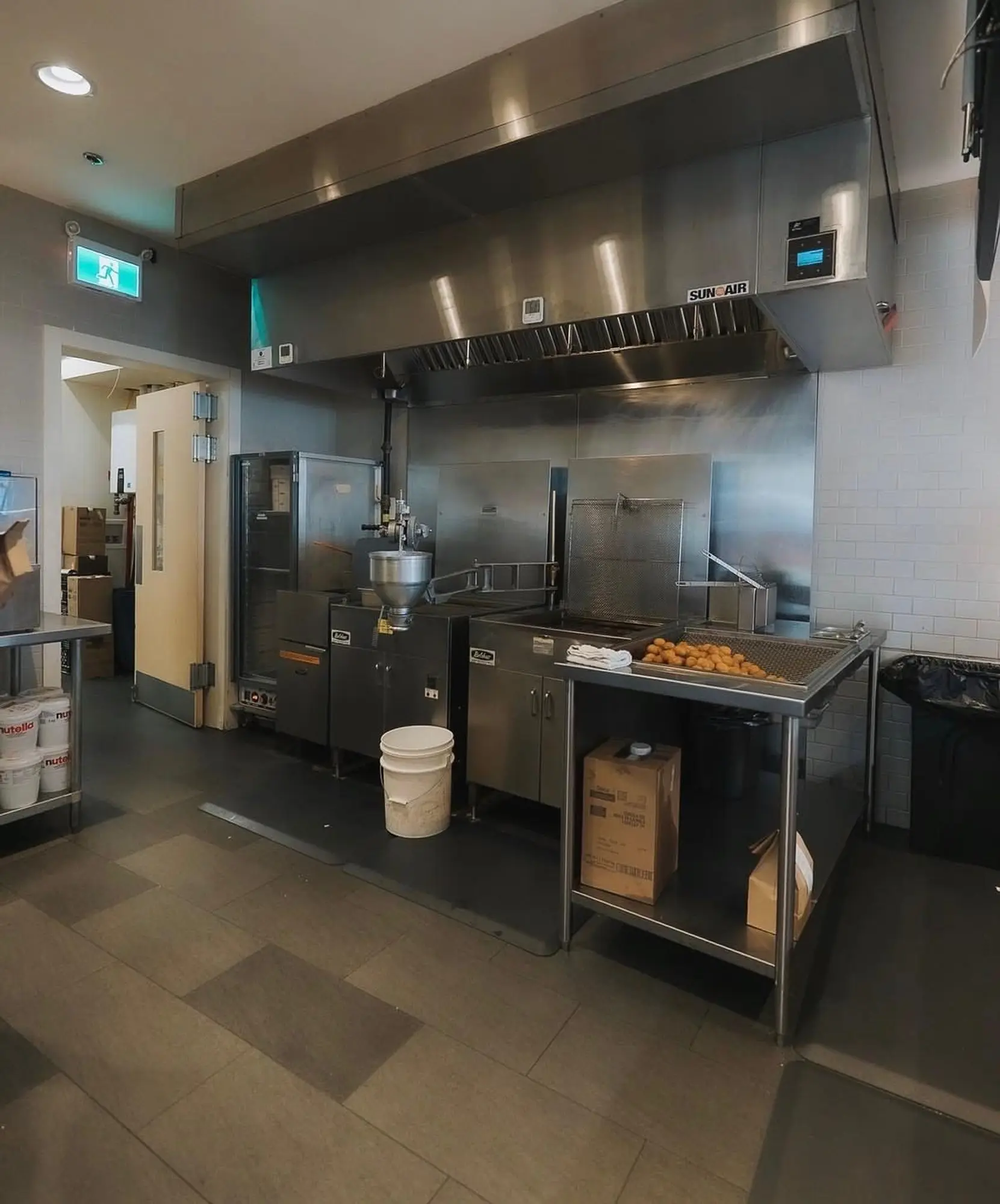 Stainless kitchen exhaust hood over the fryer line
